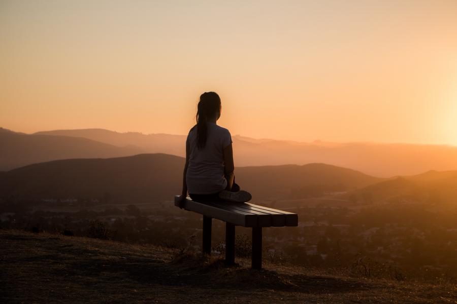 Woman sitting on bench at sunset Woman sitting on bench at sunset